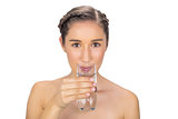 Smiling young model drinking water