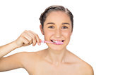 Smiling young model brushing her teeth