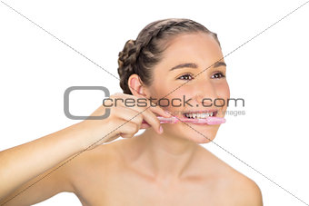 Cheerful young model brushing her teeth