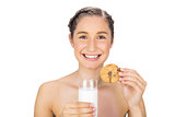 Cheerful young model holding cookie and milk