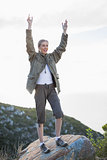 Blonde woman standing on a rock and cheering