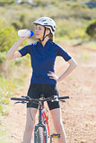 Woman with bike drinking water