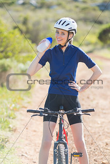 Happy woman drinking after biking