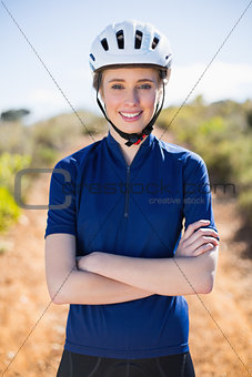 Smiling woman wearing helmet crossing arms