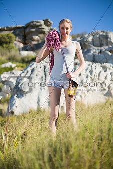 Blonde woman holding climbing equipment