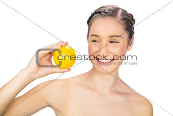 Smiling healthy model holding orange