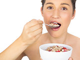 Smiling healthy model eating cereals