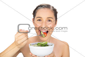 Smiling healthy model eating salad