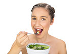 Smiling natural model eating healthy salad