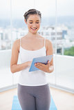 Smiling sporty model scrolling on tablet pc