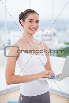Happy sporty woman using her laptop