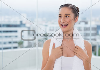 Happy sporty brunette with white towel on shoulders