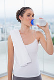 Sporty brunette drinking water from her flask