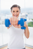 Happy athletic brunette exercising with dumbbells