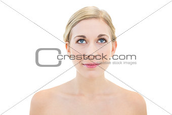 Thinking young blonde woman looking up