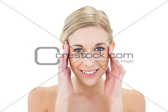 Cheerful young blonde woman posing touching her temples