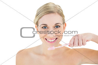 Joyful young blonde woman brushing her teeth