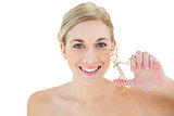 Happy young blonde woman holding eyelash curler