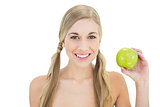Pleased young blonde woman holding a green apple