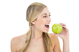 Calm young blonde woman eating an apple