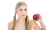 Serious blonde woman holding a red apple