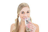 Smiling young blonde woman drinking water