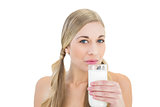 Charming young blonde woman sipping milk