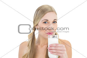 Charming young blonde woman sipping milk