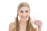 Delighted young blonde woman holding a glass of milk