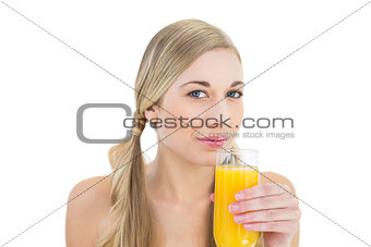 Attractive young blonde woman drinking orange juice