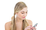 Dreamy young blonde woman using a mobile phone