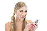 Delighted young blonde woman using a mobile phone
