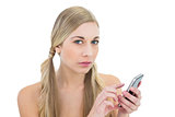 Serious young blonde woman using a mobile phone