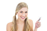 Pleased young blonde woman holding a mobile phone