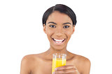 Smiling attractive model holding glass of orange juice