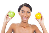 Smiling attractive model holding fruits in both hands