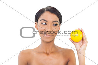 Cheerful attractive model holding orange