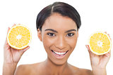 Natural attractive model holding slices of orange in both hands