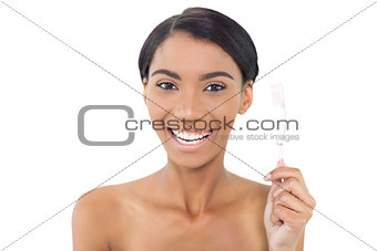 Smiling natural model holding toothbrush