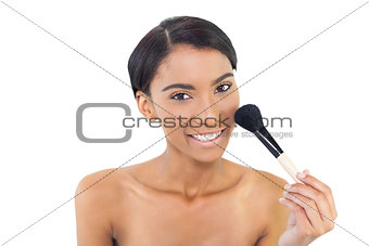 Smiling natural model using blusher brush