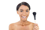 Smiling natural model holding blusher brush