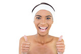 Smiling gorgeous model wearing headband giving thumbs up to camera