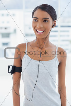Cheerful attractive model in sportswear listening to music