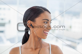 Smiling pretty model in sportswear listening to music