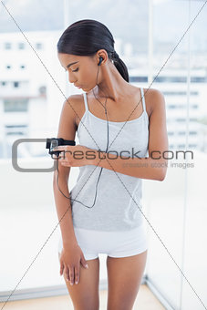 Pretty model in sportswear changing song on her mp3