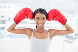 Smiling competitive model wearing red boxing gloves