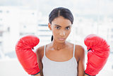 Serious competitive model with boxing gloves posing