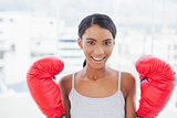 Cheerful competitive model with boxing gloves posing