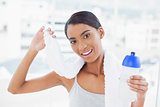 Smiling sporty model holding flask and sport towel