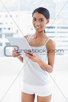Smiling sporty model holding digital tablet